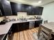 A kitchen featuring dark cabinets, stainless steel appliances, and grey countertops with natural wood flooring at 1816 Hemlock Ln, Plainfield, IN 46168