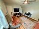 A bright living room with a ceiling fan, a comfortable sofa, a flat-screen TV, and a large area rug on wood floors at 1816 Hemlock Ln, Plainfield, IN 46168