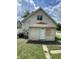 View of the home's rear exterior featuring neutral siding and a door with boarded-up window at 1902 Orange St, Indianapolis, IN 46203