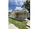 Modest home featuring a front porch, boarded windows, and vinyl siding at 1902 Orange St, Indianapolis, IN 46203