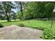 View of the expansive backyard, lush green lawn, fire pit, and mature trees at 1980 S Arthur Rd, Paragon, IN 46166