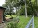 Landscaped backyard featuring mature trees and a chain-link fence at 1980 S Arthur Rd, Paragon, IN 46166