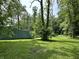 Spacious backyard with lush lawn, trees, and a shed, creating a serene outdoor retreat at 1980 S Arthur Rd, Paragon, IN 46166