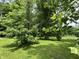 Green backyard oasis with mature trees providing ample shade and a tranquil atmosphere at 1980 S Arthur Rd, Paragon, IN 46166