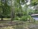 Landscaped backyard featuring a rustic fence, mature trees, and a shed, perfect for outdoor enjoyment at 1980 S Arthur Rd, Paragon, IN 46166