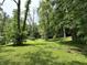 Expansive backyard featuring lush green lawn and mature trees providing shade and privacy at 1980 S Arthur Rd, Paragon, IN 46166