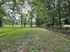 Expansive green space with mature trees and a rustic fence, offering a serene backyard setting at 1980 S Arthur Rd, Paragon, IN 46166