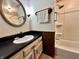 Functional bathroom featuring a vanity with a sink, a large round mirror, and a shower-tub combination at 1980 S Arthur Rd, Paragon, IN 46166