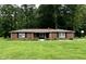 Charming brick ranch home featuring a well-manicured lawn and beautiful, mature trees offering shade and privacy at 1980 S Arthur Rd, Paragon, IN 46166
