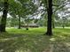 Beautiful single-story home with brick exterior and spacious green lawn surrounded by mature trees at 1980 S Arthur Rd, Paragon, IN 46166