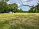 Expansive grassy field with a storage shed and surrounded by lush trees at 1980 S Arthur Rd, Paragon, IN 46166