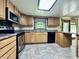 Functional kitchen with stainless steel appliances, wood cabinets, and ample counter space under a skylight at 1980 S Arthur Rd, Paragon, IN 46166