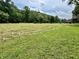 Expansive land offering with large manicured front lawn and wooded area, creating a private setting at 1980 S Arthur Rd, Paragon, IN 46166