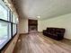 Comfortable living room with new floors, a brick fireplace, and a bright window to enjoy the outdoors at 1980 S Arthur Rd, Paragon, IN 46166