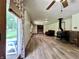 Open living room with wood-look floors, wood stove, brick fireplace, and natural light at 1980 S Arthur Rd, Paragon, IN 46166