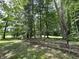 Scenic view along the property line with lush greenery, mature trees, and a rustic wooden fence at 1980 S Arthur Rd, Paragon, IN 46166