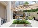 Spacious patio with outdoor furniture, plants, and an umbrella for shade at 25 E 40Th St # Apt 1B/D, Indianapolis, IN 46205