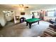 Spacious basement featuring a pool table, comfortable seating, and natural light at 2615 Alexandria Pike, Anderson, IN 46012