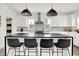 A kitchen featuring an island with a black countertop and four chairs, stainless steel appliances, and gray subway tile backsplash at 2720 Guilford Ave, Indianapolis, IN 46205