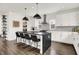 A kitchen with white cabinets, stainless steel appliances, an island with seating for four, and dark wood floors at 2720 Guilford Ave, Indianapolis, IN 46205