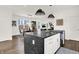Open kitchen concept with black island, white cabinets, stainless steel appliances, and adjacent dining and living areas at 2720 Guilford Ave, Indianapolis, IN 46205