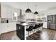 Kitchen featuring stainless steel appliances, a kitchen island with seating, pendant lights, and hardwood flooring at 2720 Guilford Ave, Indianapolis, IN 46205