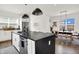 A spacious kitchen with a black island, stainless steel appliances, and an adjacent dining area at 2720 Guilford Ave, Indianapolis, IN 46205