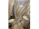 Bathroom featuring patterned tile, a shower with curtain, toilet, sink, and vanity with toiletry storage at 2824 Brown St, Anderson, IN 46016