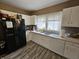 Functional kitchen featuring white cabinetry, wood-look floors, and essential appliances for a comfortable living experience at 2824 Brown St, Anderson, IN 46016