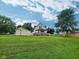 Spacious backyard with a deck, detached garage, and mature trees at 3015 Mckinley Ave, Columbus, IN 47201