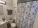 Bathroom with vanity, toilet, and shower with a patterned curtain, plus built-in shelving for storage at 3015 Mckinley Ave, Columbus, IN 47201