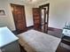 Bedroom with wood floors, ceiling fan, three doors, and a gray rug at 3015 Mckinley Ave, Columbus, IN 47201