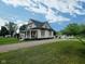 Charming home with a covered front porch, gravel driveway, and a well-maintained lawn at 3015 Mckinley Ave, Columbus, IN 47201