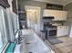Bright kitchen featuring white cabinets, stainless steel appliances, and a large sink beneath a window at 3015 Mckinley Ave, Columbus, IN 47201