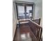 A small office space with a wood desk and monitors on an upper floor landing by a staircase at 3015 Mckinley Ave, Columbus, IN 47201
