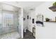 Bright bathroom featuring walk-in shower with a glass block window and modern white wood paneling at 4511 W 300 S, Anderson, IN 46011