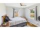 Cozy bedroom with a wooden bed frame, patterned bedding, wood floors and view to the fenced backyard at 4511 W 300 S, Anderson, IN 46011