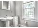 Bathroom features a pedestal sink, a storage cabinet and a window for natural light at 4904 N Washington Blvd, Indianapolis, IN 46205
