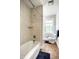 Bathroom featuring a shower over tub and a toilet near a bright window at 4904 N Washington Blvd, Indianapolis, IN 46205