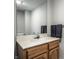 Close up of a half bathroom with a light countertop, wooden cabinets, mirror, and dark gray hand towels at 4904 N Washington Blvd, Indianapolis, IN 46205