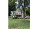 Two-story home with a screened front porch surrounded by greenery and a spacious lawn at 4904 N Washington Blvd, Indianapolis, IN 46205