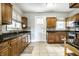 Cozy kitchen featuring brown cabinets, granite countertops, and stainless steel appliances at 4904 N Washington Blvd, Indianapolis, IN 46205