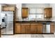 Bright kitchen featuring stainless steel refrigerator, wood cabinets, and granite counters at 4904 N Washington Blvd, Indianapolis, IN 46205