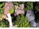 Aerial view of a private home surrounded by lush trees showcasing a wooden deck, landscaping, and private driveway at 5240 Windridge Dr, Indianapolis, IN 46226