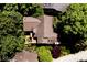 An aerial view reveals a home with a brown roof and wooden deck surrounded by lush trees and manicured landscaping at 5240 Windridge Dr, Indianapolis, IN 46226
