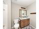 Bathroom features a wooden vanity, white countertop, framed mirror, and standard toilet at 5240 Windridge Dr, Indianapolis, IN 46226