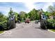 Home's entrance gate featuring stone pillars, ornate iron gates, and a charming guard house at 5240 Windridge Dr, Indianapolis, IN 46226