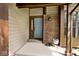Inviting front porch with brick accents, light fixture, and light blue front door with a window and side panel at 5240 Windridge Dr, Indianapolis, IN 46226
