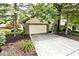 A two-car garage with a concrete driveway is surrounded by mulch and a large tree at 5240 Windridge Dr, Indianapolis, IN 46226