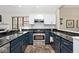 Updated kitchen with blue cabinets, stainless steel appliances, and granite countertops at 5240 Windridge Dr, Indianapolis, IN 46226